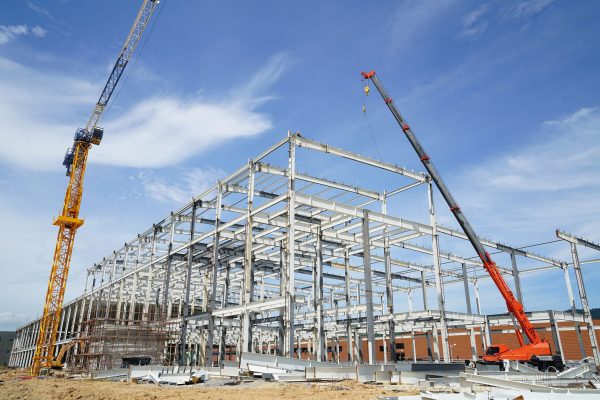 Structure,Building,Of,Steel,Structure,Roof,Truss,Frame,Installation,By Structure building of steel structure roof truss frame installation by mobile crane under the construction building in the factory with blue sky